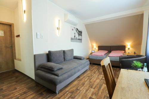 een woonkamer met een bank en een bed bij Hotel Am Dalwigker Tor in Korbach