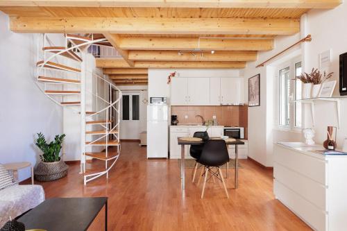 eine Küche und ein Wohnzimmer mit einer Wendeltreppe im Loft in der Unterkunft Calypso Apartment by Konnect, Corfu Old Town in Korfu-Stadt