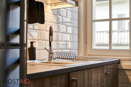 um balcão de cozinha com um lavatório e uma janela em R7 Design Apartment - hostAID em Budapeste