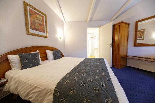 Postel nebo postele na pokoji v ubytování Charme Hôtel et Spa, Montbéliard Sud