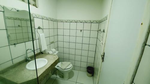 uma casa de banho com um lavatório, um WC e um espelho. em Pousada Pedras do Porto em Porto de Galinhas