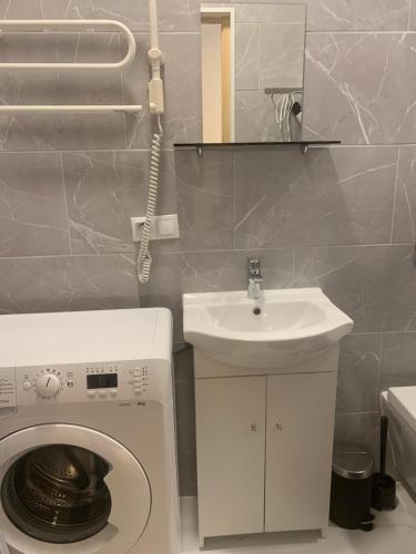 a bathroom with a washing machine and a sink at Verman Park Apartment in Rīga