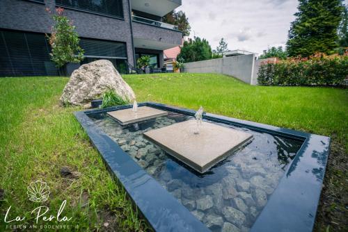 a garden with a fountain in the middle of a yard at La Perla in Lindau
