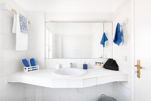 a white bathroom with a sink and a mirror at Aeginia 1- Breathtaking sea view house in Perdika in Perdika