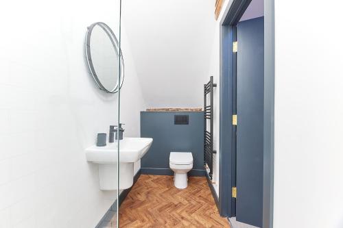 a bathroom with a white toilet and a mirror at No 8 at Simpson Street Apartments Sunderland in Sunderland