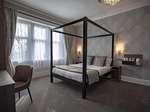a bedroom with a four poster bed and a window at Sure Hotel by Best Western Lockerbie in Lockerbie