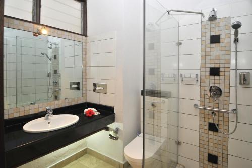 ein Bad mit einem Waschbecken und einer Dusche in der Unterkunft Bahari Beach Hotel in Mombasa