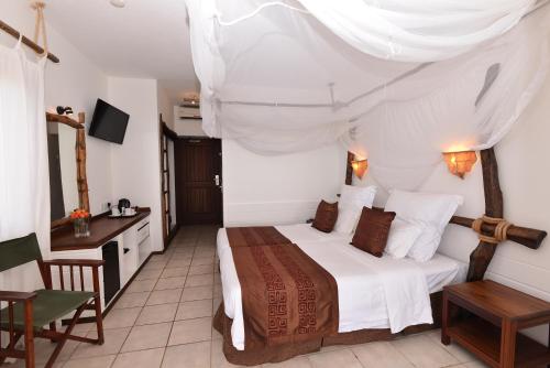 a bed room with a white bedspread and pillows at Bahari Beach Hotel in Mombasa