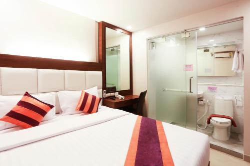 Schlafzimmer mit einem Bett und einer Glasdusche in der Unterkunft Studio Nana by iCheck inn in Bangkok