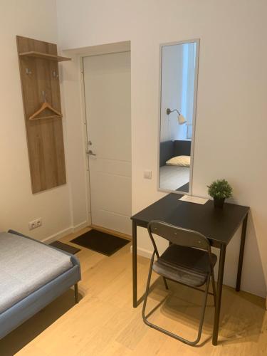 a bedroom with a table and a mirror and a bed at Verman Park Apartment in Rīga