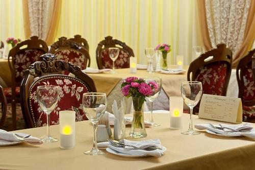 una mesa larga con copas de vino y flores. en Metelitsa Hotel, en Krasnoyarsk