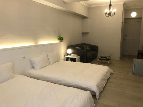 two beds in a room with a couch and a living room at 海沐輕旅 Sea Mu Kenting in Nanwan