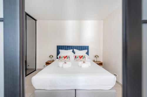 a bedroom with a white bed with two pillows at 45 Croisette Apartment - Prime Location - Beach & Palais by Foot - AC in Cannes