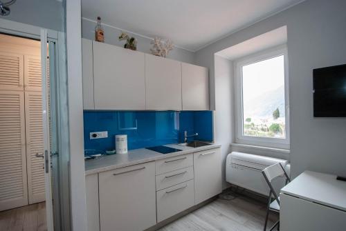a kitchen with white and blue cabinets and a window at Dal Comandante by Arbaspàa in Manarola