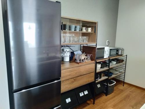 a kitchen with a stainless steel refrigerator at 山里の家 in Nanjo