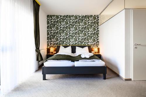 1 dormitorio con 1 cama con pared de flores en Thermenhof Lutzmannsburg - Inklusive Thermeneintritt, en Lutzmannsburg