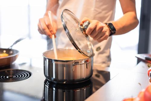 a man is stirring a pot on a stove at Luxury Apart Sailers including Premium Summercard in Sankt Anton am Arlberg