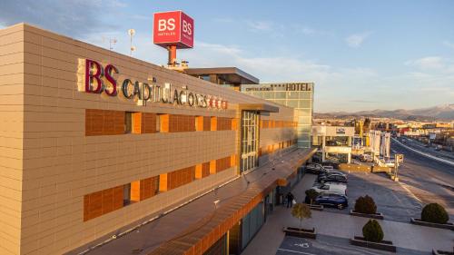 a building with a sign on top of it with a parking lot at BS Capitulaciones in Santa Fe