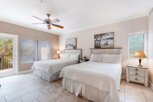 een slaapkamer met 2 bedden en een plafondventilator bij 2533 Tennis Villas Efficiency in Fernandina Beach