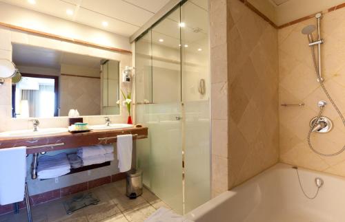 
a bathroom with a shower, sink, and tub at Senator Banus Spa Hotel in Estepona
