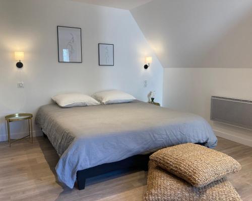 1 dormitorio con 1 cama grande y 1 silla en L’atelier d’Auguste, en Marcols-les-Eaux