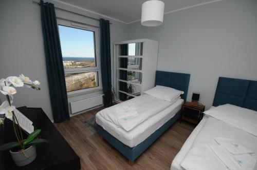 グダニスクにあるApartament Horyzontのベッドルーム1室(ベッド2台、大きな窓付)