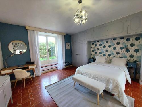 a bedroom with a bed and a desk and a window at Chbre Tamara du Château avec Piscine in Pépieux