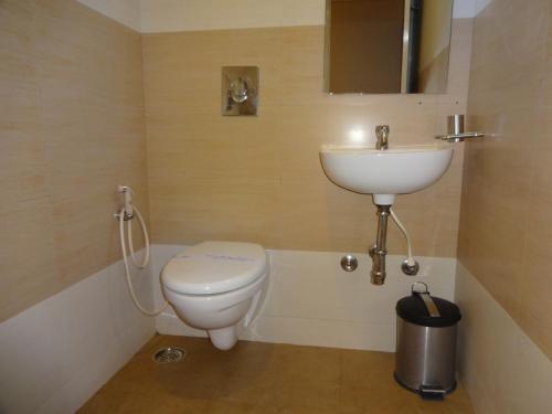 a bathroom with a toilet and a sink at Hotel Sky Lite in Coimbatore