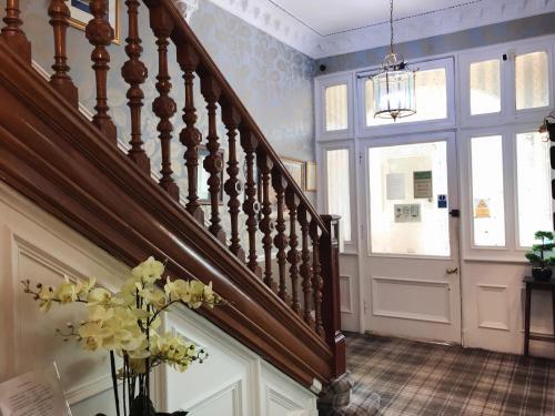 a room with a staircase leading to a balcony at Alexander Guest House in Edinburgh