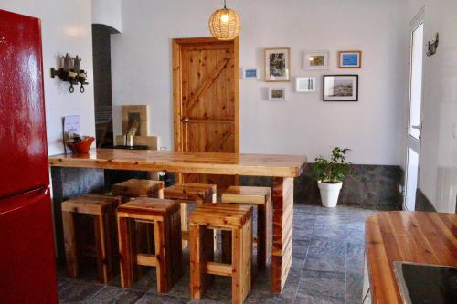 a kitchen with a wooden counter and stools at Sea Roots "Sea Zone" in Mosteiros