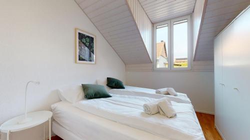 1 dormitorio con 1 cama blanca grande y ventana en Nice apartments at 10min from Payerne, fully equipped, en Vers chez Perrin