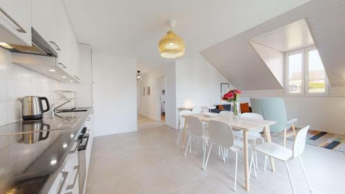 a kitchen and dining room with a white table and chairs at Nice apartments at 10min from Payerne, fully equipped in Vers chez Perrin