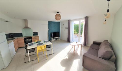 ein Wohnzimmer mit einem Sofa und einem Tisch sowie eine Küche in der Unterkunft LA PIERRINA - Marmotte - Appart 3 étoiles in Aix-les-Bains