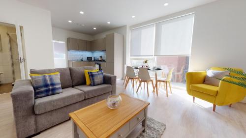 een woonkamer met een bank en een tafel bij Luxury Apartment - Town Centre North Stevenage in Stevenage