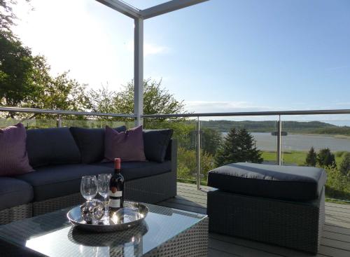 a patio with a couch and a table with wine glasses at Ferienvilla mit Panoramablick auf den Schmachter See in Binz
