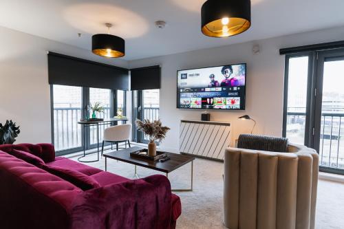 a living room with a purple couch and a tv at The Lusso Suite - 2BR - A 5* Escape Like No Other in Glasgow