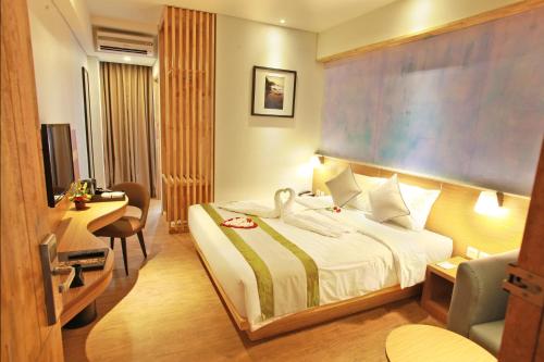 una camera d'albergo con letto e scrivania di Liberta Hotel Jimbaran a Jimbaran