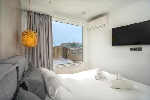 um quarto com uma cama branca e uma grande janela em Stylish Living-Parthenon em Atenas