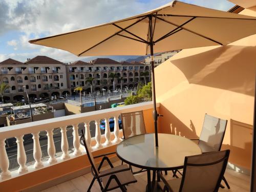 einen Balkon mit einem Tisch und einem Sonnenschirm in der Unterkunft Comfortable Apartment Los Cristianos. Free Wifi. in Arona