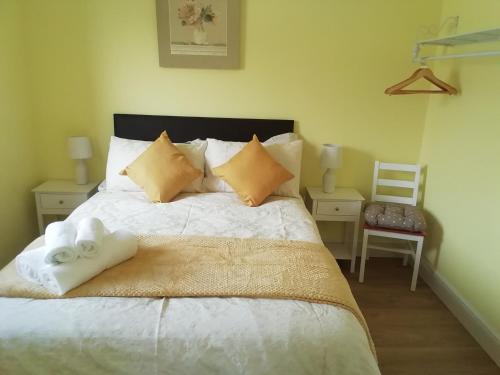 a bedroom with a bed with white sheets and pillows at Wilma's Guest House in Dundonnell
