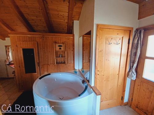a large tub in a room with a wooden ceiling at Romantic Spa in Venas