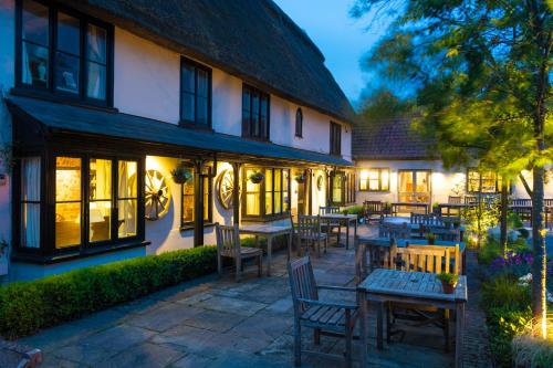 a patio with tables and chairs in front of a building at The Black Bull Inn in Balsham