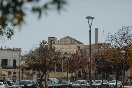 um parque de estacionamento com carros estacionados em frente a um edifício em Le Camporelle In Città em Lecce