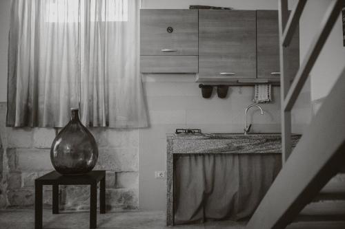 uma cozinha com um vaso sentado num banco ao lado de uma mesa em Le Camporelle In Città em Lecce