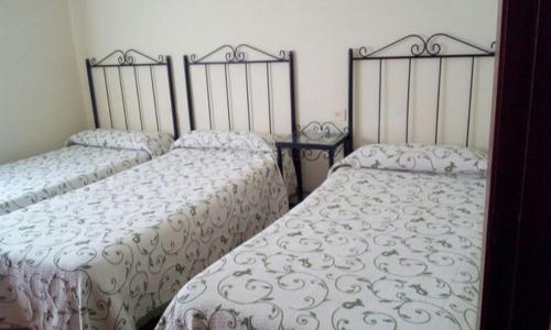 ポルトノボにある2 D Las Floresのベッドルーム1室(隣り合わせのベッド2台付)