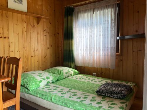 a bed in a wooden room with a window at Domki Letniskowe in Jastarnia