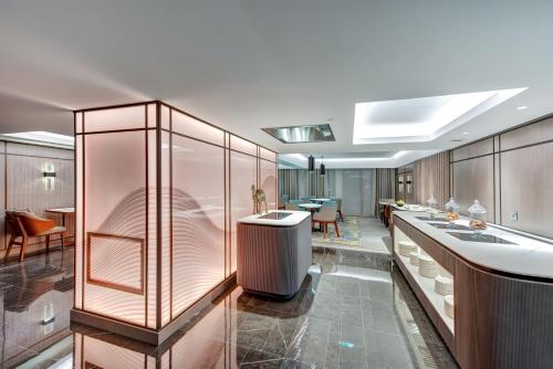 a kitchen with a counter and a dining room at InterContinental Muscat by IHG in Muscat
