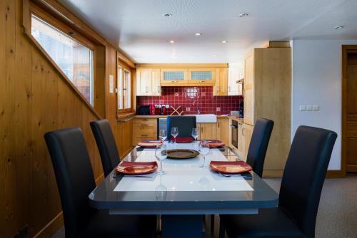 une cuisine avec une table et des chaises ainsi qu'un astérisque dans l'établissement Appartement Le Galetas des Planards, à Chamonix-Mont-Blanc
