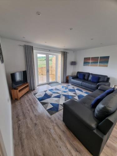 a living room with a couch and a tv at Fairway View Cottage in Rothbury