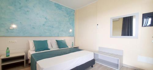 a bedroom with a white bed and a blue wall at I Fichi D'India Rooms in Capo Vaticano